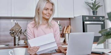 Older woman looks at her laptop to understand her QDRO filing