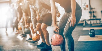 Group uses kettlebells at workout class