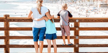 young mom and kids together on a pier beach overlook