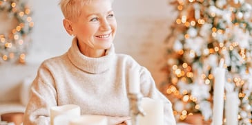 woman happy and cozy in a candlelit room with fairy lights