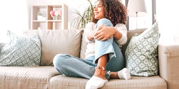 woman sitting alone on a couch and thinking