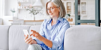 Older woman uses her smartphone to search for information about QDROs