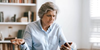 woman looking at harassing texts from her ex in frustration