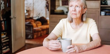 retired woman alone at home sipping coffee
