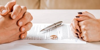two pairs of folded hands over divorce decree