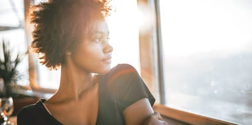 woman looking peaceful and thoughtful in sunrise