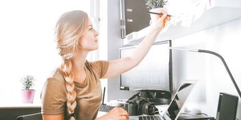 blonde woman sits at computer getting work done