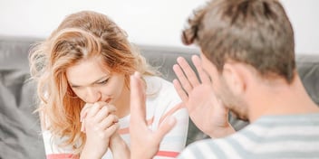 woman looks away while man explains himself