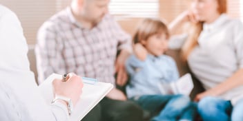 kid sitting between parents on therapy couch
