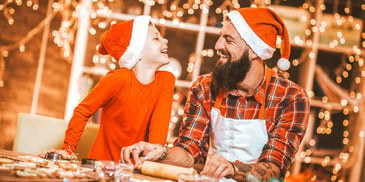 dad and kid smiling in santa hats