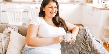 woman smiling alone on couch