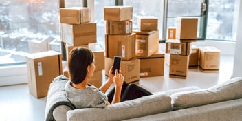 woman with boxes in city apartment window