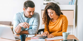 couple sitting with calculator between them