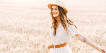 woman smiling as she walks through a field