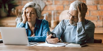 couple sitting at computer frowning