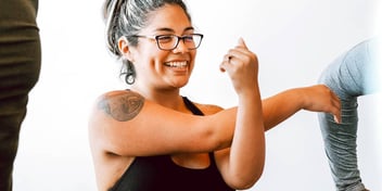 young woman smiling and flexing her bicep