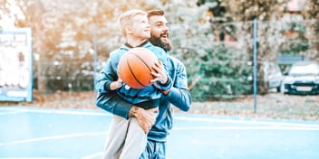 dad lifts son and son holds basketball