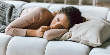 woman lying on couch upset