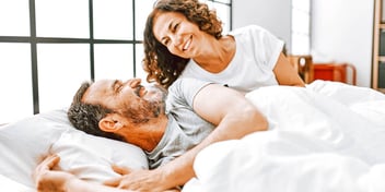 smiling, laughing man and woman in bed