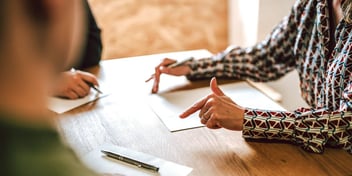 two people completing legal paperwork at a table