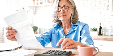 woman going over her finances and using a calculator