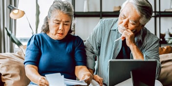 confused looking older Asian couple trying to complete divorce paperwork
