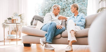 older couple stubbornly sitting next to each other on couch