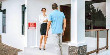 realtor greeting a man at an open house
