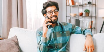 man smiling as he talks on the phone