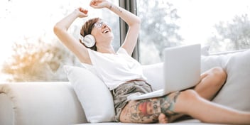happy woman laughing and listening to something on headphones
