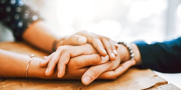 two people holding hands in support