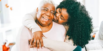 adult daughter embracing her mother and smiling