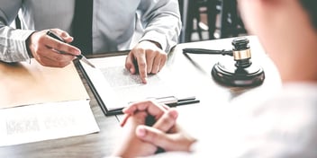 judge or lawyer pointing to divorce papers to sign