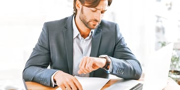 man in a business suit looking at his watch