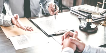 two people in a legal setting going over paperwork