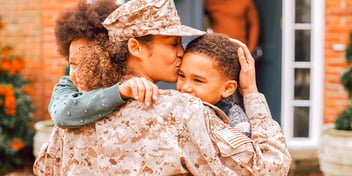 woman in marines military uniform hugging and kissing her kids outside ex husbands home