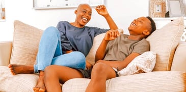 mom and son laughing and relaxing on a couch