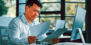 man going over lots of paperwork and forms