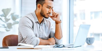 pensive man reading something on his laptop