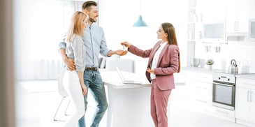 real estate agent handing a couple keys to their new house