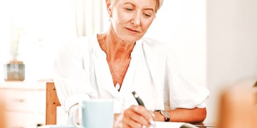 older woman writing in a notebook