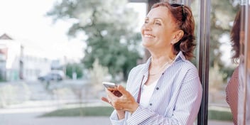 smiling woman holding her phone after a reassuring call
