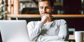 smug-looking man looking at his computer