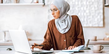 woman wearing a hijab working on paperwork
