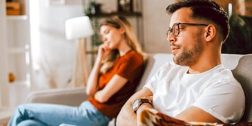 unhappy couple sitting apart on a couch considering a legal separation