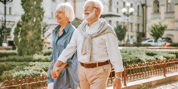 smiling couple walking hand in hand in a park