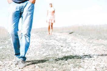 man walking ahead of a woman at a beach