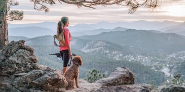 Woman on a hike in the mountains with her dog