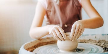Woman makes a pot during pottery class