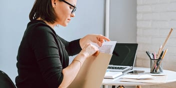 woman putting papers in an envelope